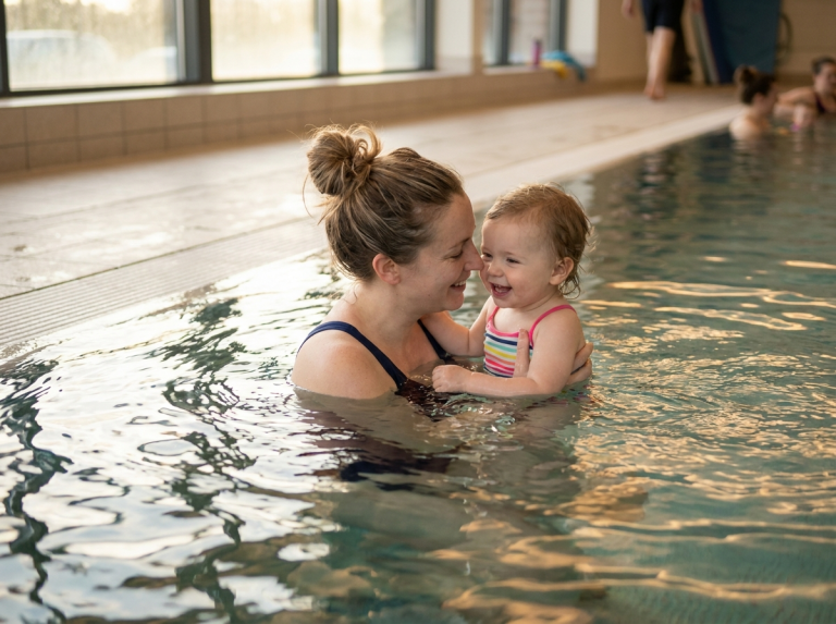 Mere tenant son enfant dans une piscine